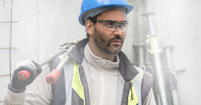 Man on a construction site wearing safety goggles