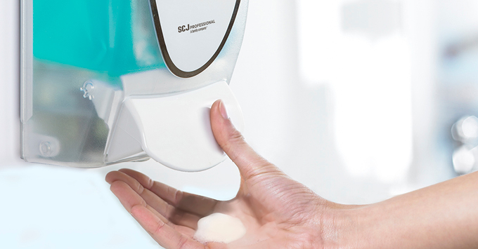 A hand using a cartridge soap dispenser