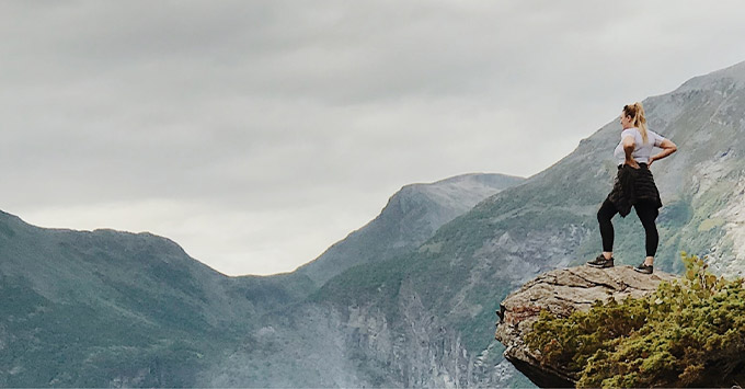 Woman looking over the edge of a cliff