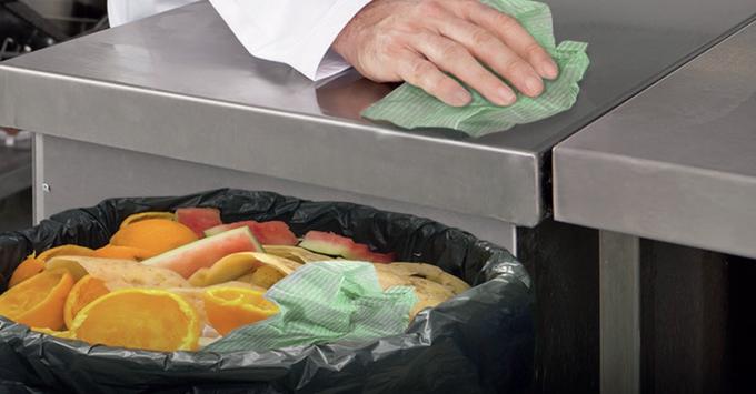 Man using a compostable cloth in a kitchen 