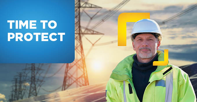 Man wearing PPE next to telephone mast
