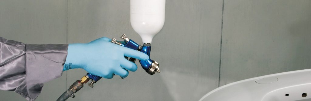person wearing protective gloves while using chemicals