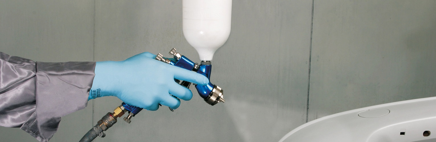 person wearing protective gloves while using chemicals