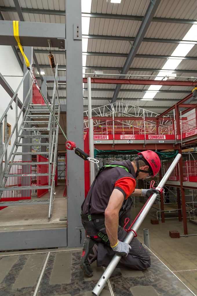 Worker uses anchor point installed above the work area